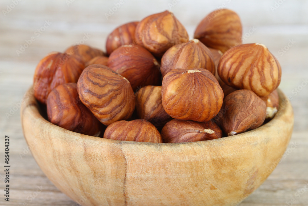 Hazelnuts in wooden bowl, close up Hazelnuts in wooden bowl, close up