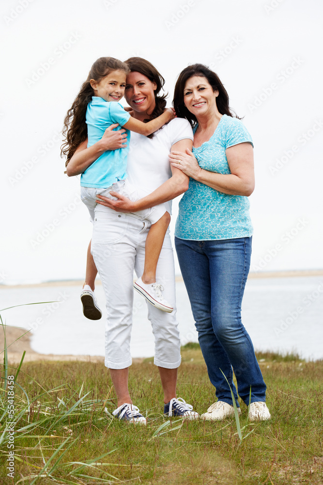 Female Members Of Multi Generation Family Standing By Sea Female Members Of Multi Generation Family Standing By Sea