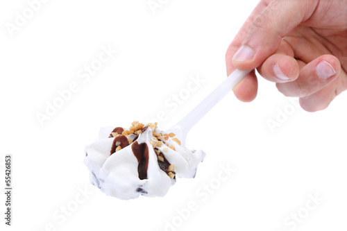 Hand holds ice cream on a spoon.