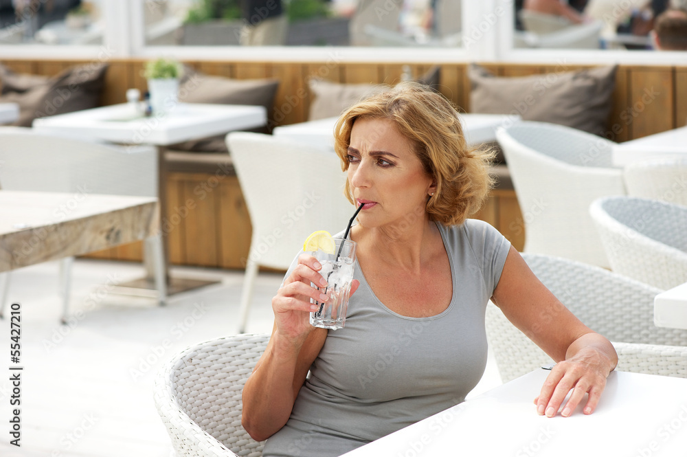 Woman drinking water at outdoors restaurant