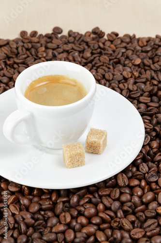 fine espresso in cup on coffee beans