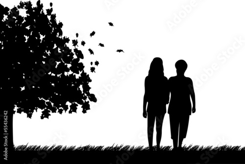Mother and daughter walking in park in autumn