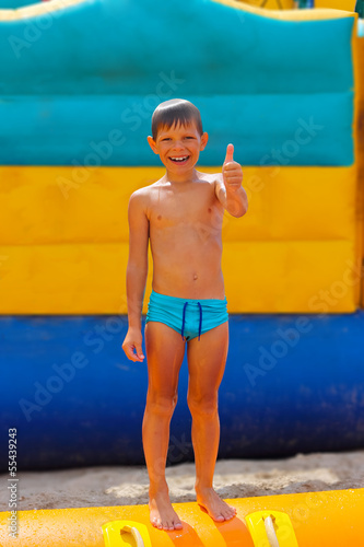 Smiling boy on blue swimming trunks during his summer vacation