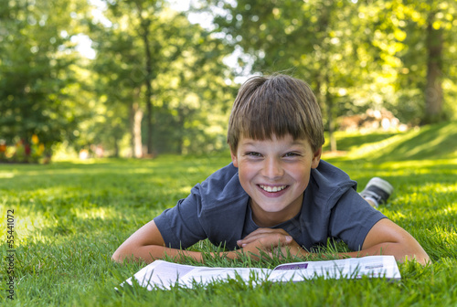 Smiling happy boy reading book