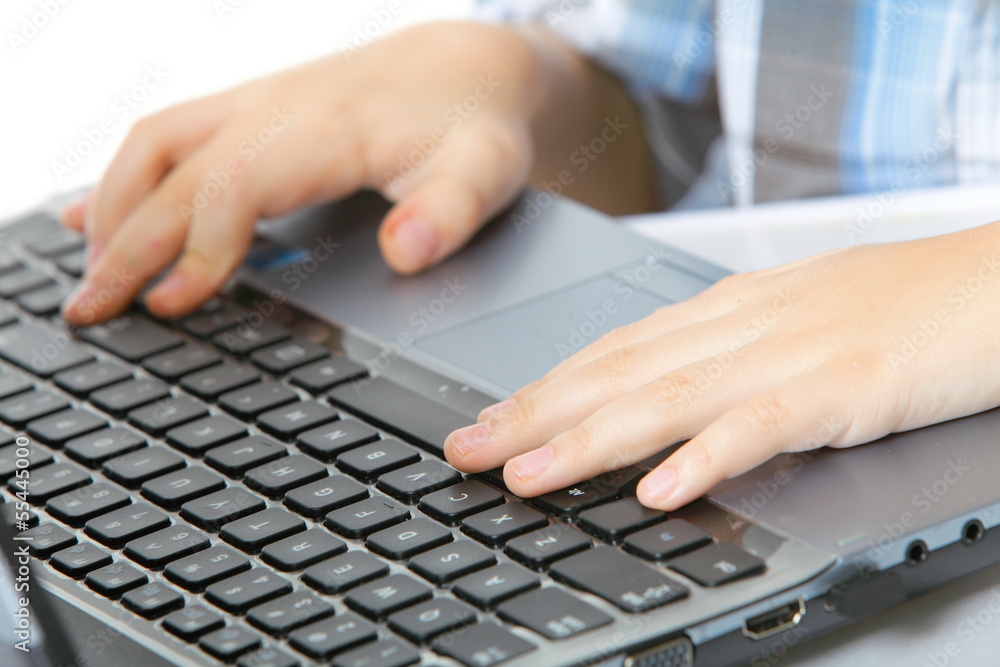 boy's hand typing on laptop keyboard boy's hand typing on laptop keyboard