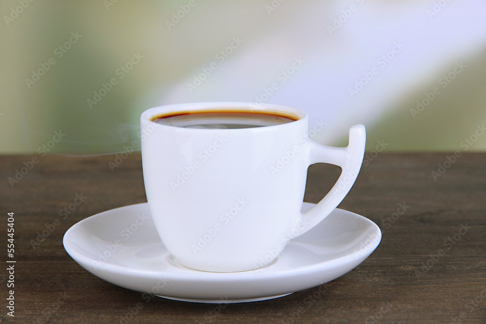 Cup of coffee on wooden table on bright background Cup of coffee on wooden table on bright background