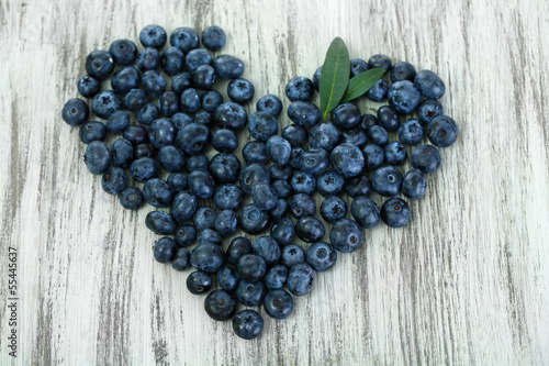 Heart of blueberries on wooden background