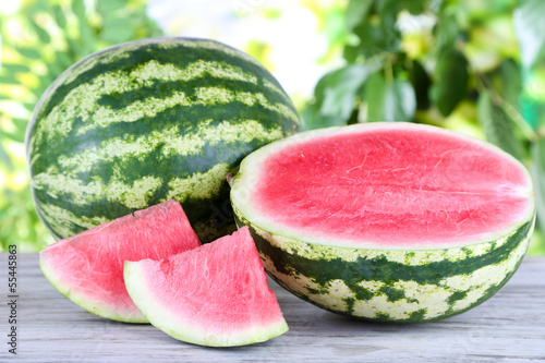 Ripe watermelons on wooden table on nature background
