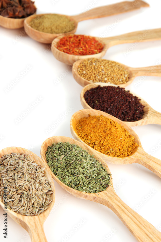 Assortment of spices in wooden spoons, isolated on white Assortment of spices in wooden spoons, isolated on white
