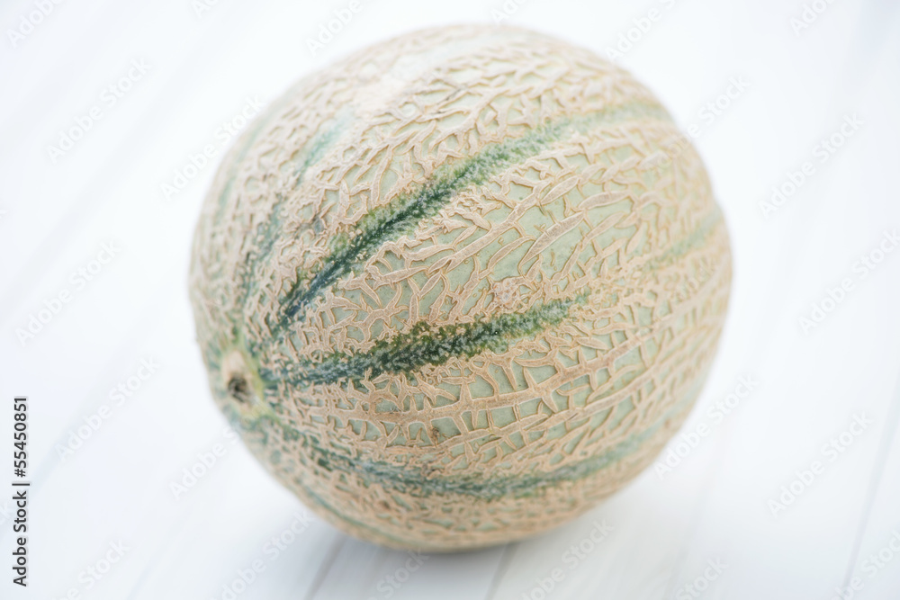 Cantaloupe melon over white wooden boards, studio shot Cantaloupe melon over white wooden boards, studio shot