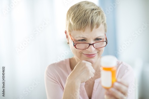 Woman Reading Label On Pill Bottle