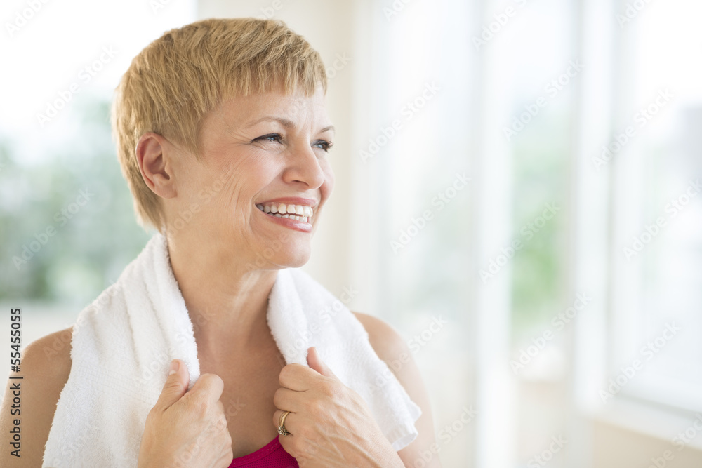 Woman With Towel Around Neck Laughing At Gym