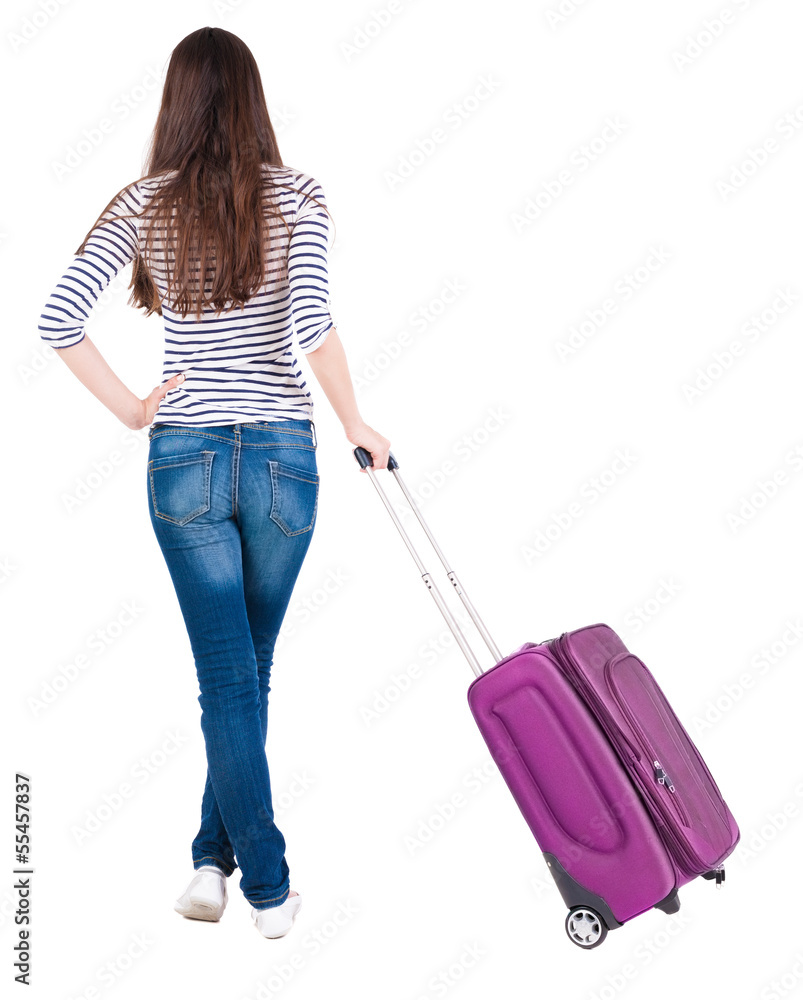 Back view of stylishly dressed brunette woman with suitcase lo Back view of stylishly dressed brunette woman with suitcase lo