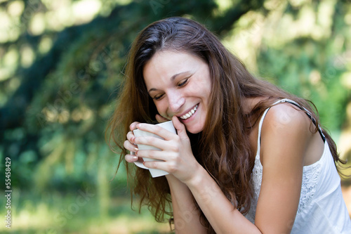 Beautiful smiling Girl Drinking Tea or Coffee at park