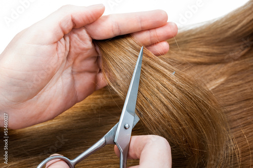 hands of hairdresser cutting woman’s hair