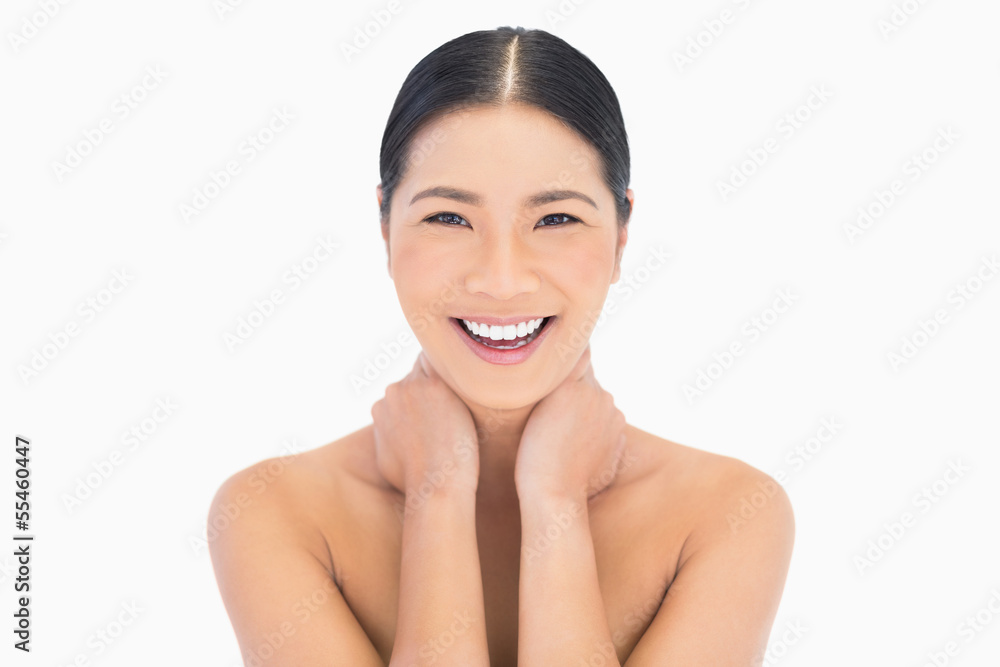 Cheerful natural model posing touching her neck Cheerful natural model posing touching her neck