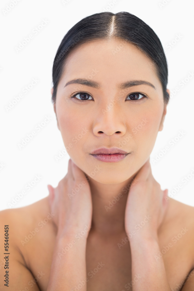 Serious pretty natural model posing with hands on her neck Serious pretty natural model posing with hands on her neck