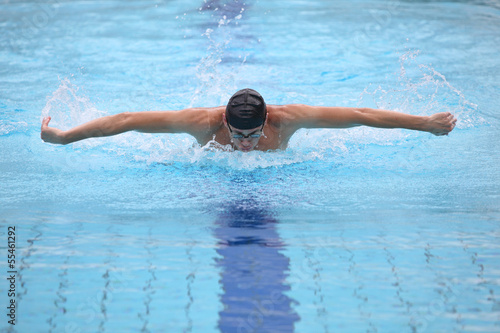 dynamic, fit swimmer breathing performing the butterfly stroke