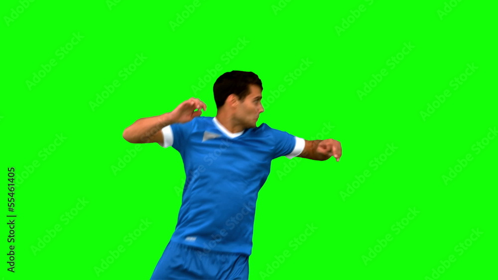 Handsome man heading a football on green screen Handsome man heading a football on green screen