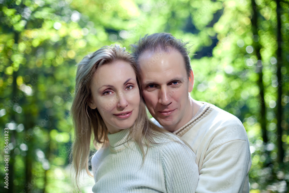 Loving couple on a background of green foliage.