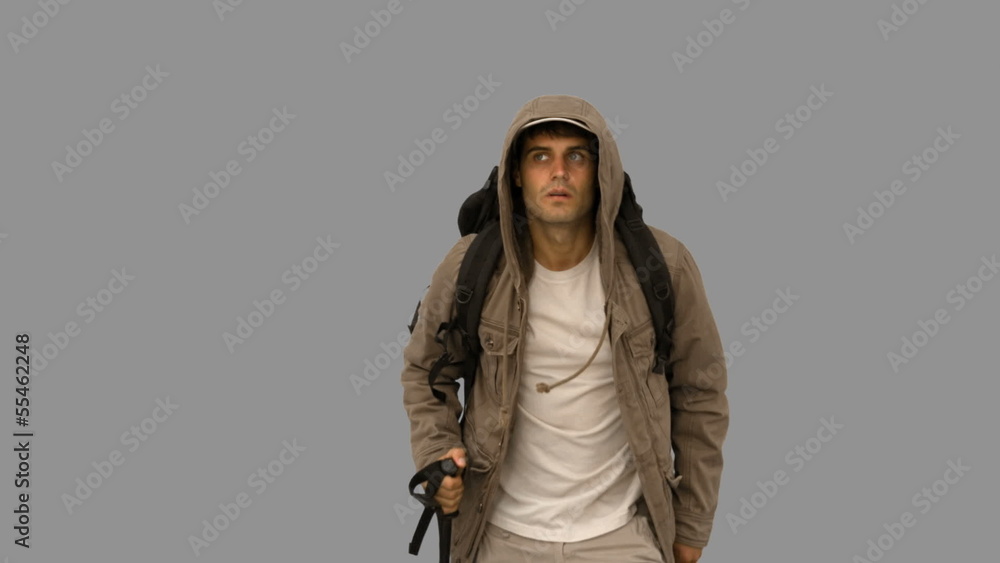 Attractive man with a coat trekking on grey screen Attractive man with a coat trekking on grey screen