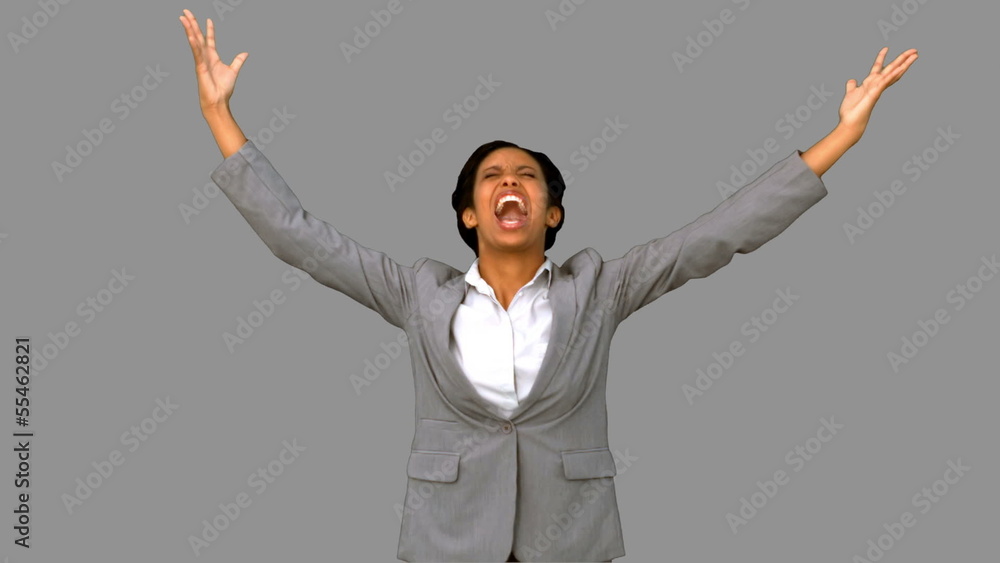 Angry businesswoman raising arms on grey screen Angry businesswoman raising arms on grey screen