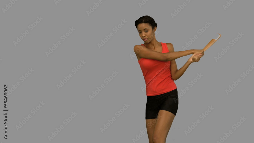 Pretty woman playing baseball on grey screen Pretty woman playing baseball on grey screen