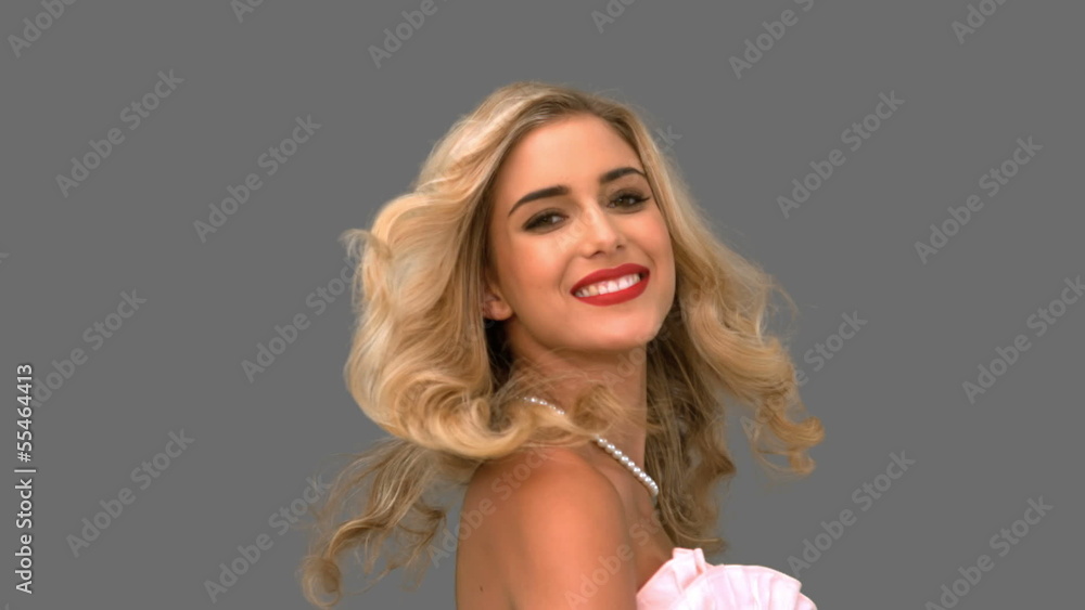 Pretty woman tossing her hair on grey screen Pretty woman tossing her hair on grey screen
