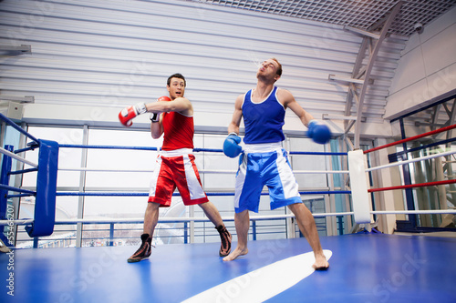 Kickboxing. Two kickboxers fighting on the boxing ring © BlueSkyImages