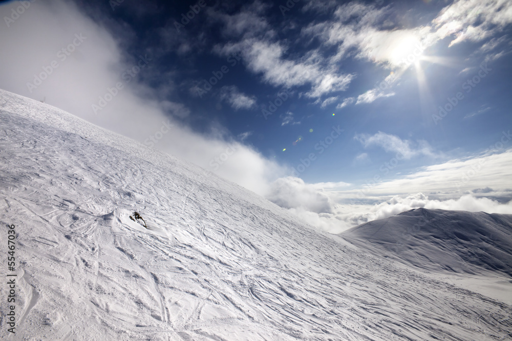 Off-piste ski slope and blue sky with sun Off-piste ski slope and blue sky with sun