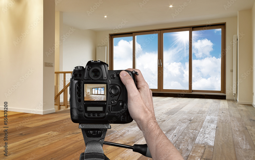 Man photographing empty living room with digital camera