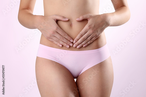Woman's hands on stomach on white background © amedeoemaja