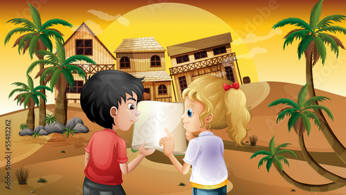 A girl and a boy holding an empty book at the desert