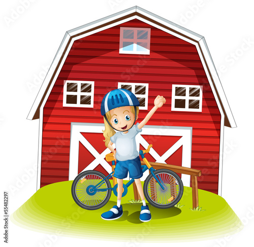 A female biker standing in front of the red barnhouse