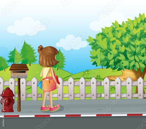 A girl standing near the mailbox at the roadside