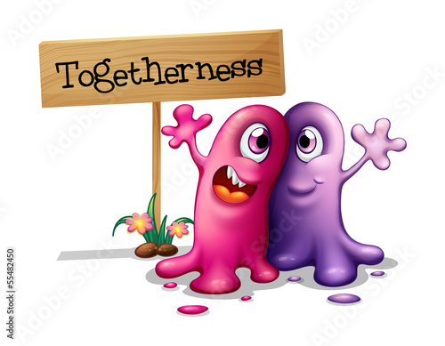 A pink and a purple monster beside a signboard