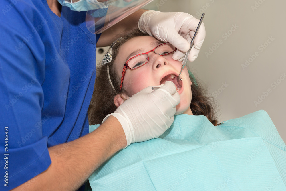 Dentist examining a girl teenager Dentist examining a girl teenager
