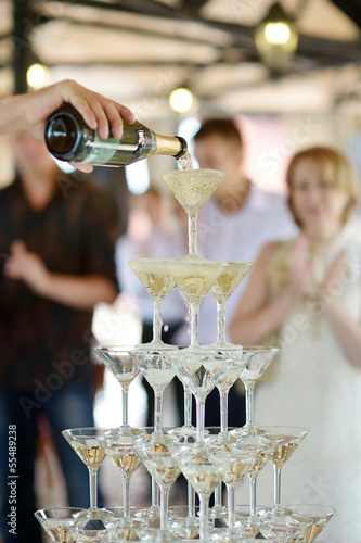 Obraz na plátne Pouring champagne into glasses