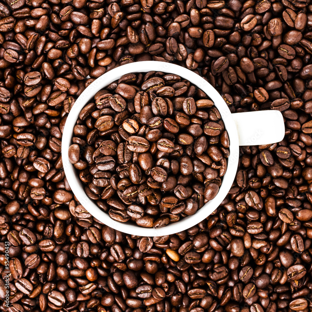 White cup full of coffee beans on Roasted Coffee Beans backgrou White cup full of coffee beans on Roasted Coffee Beans backgrou