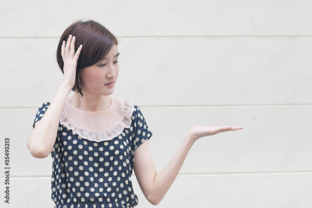 Asian young woman with headache showing product or text Asian young woman with headache showing product or text