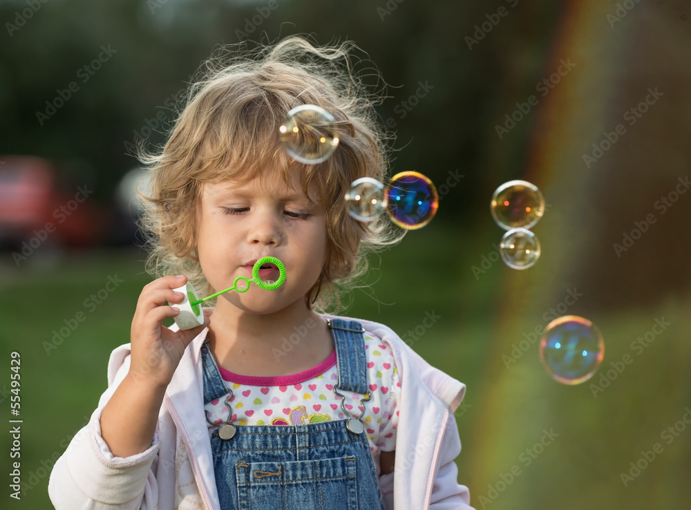 The little girl inflates soap bubbles The little girl inflates soap bubbles