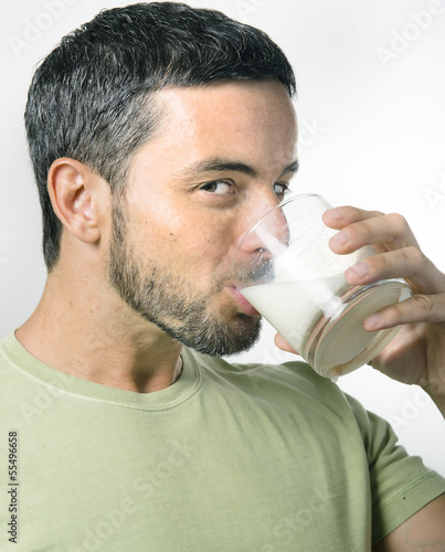 Young Handsome Man with Beard drinking Milk