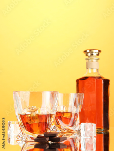 Bottle and two glasses of scotch whiskey, on color background