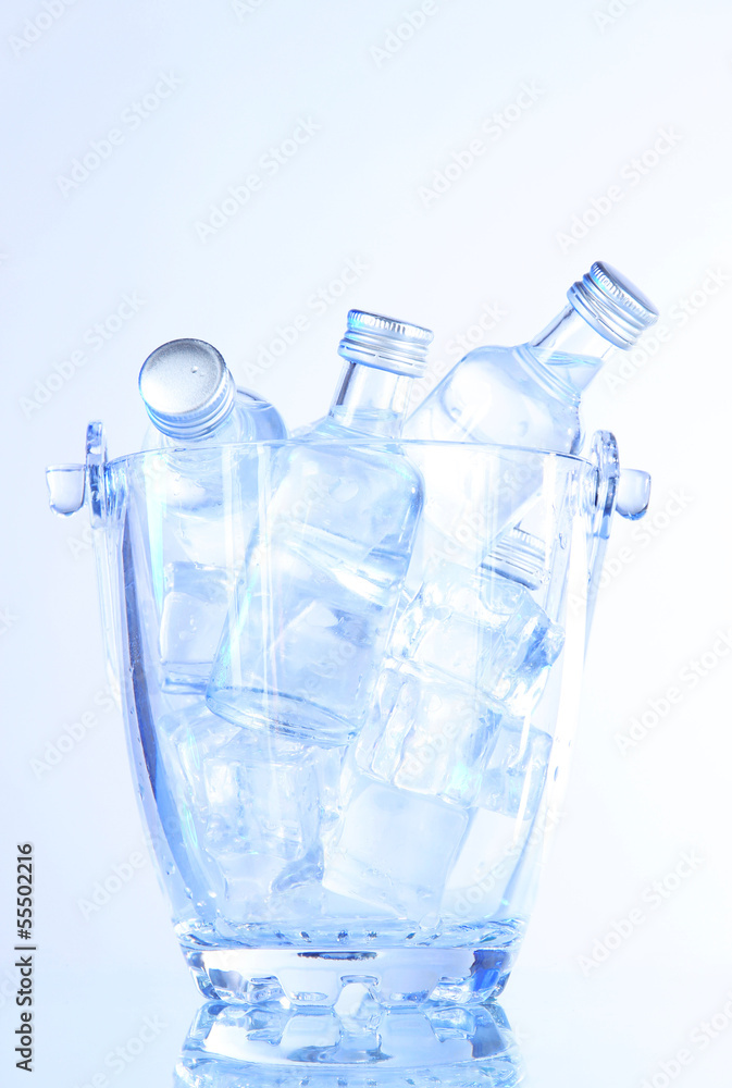 Minibar bottles in bucket with ice cubes, isolated on white Minibar bottles in bucket with ice cubes, isolated on white