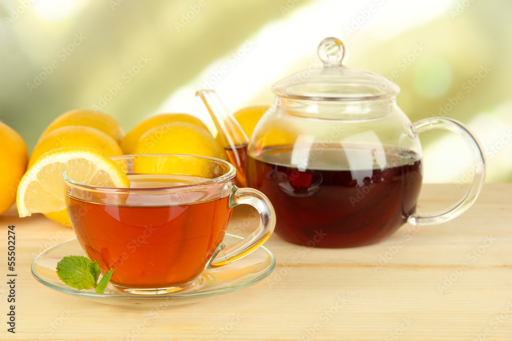 Cup of tea with lemon on table on light background Cup of tea with lemon on table on light background