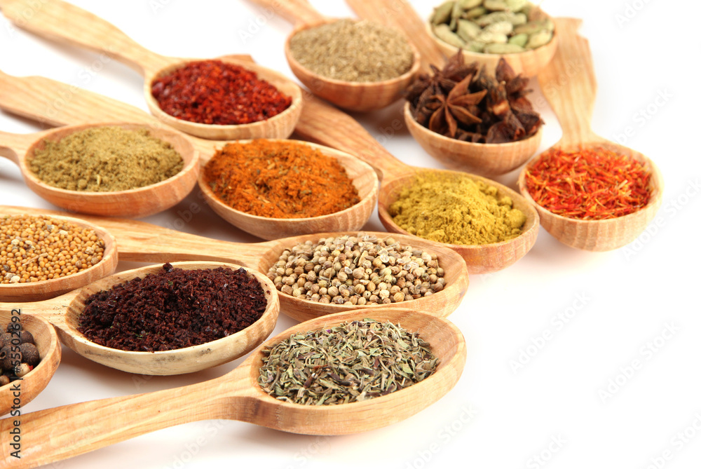 Assortment of spices in wooden spoons, isolated on white Assortment of spices in wooden spoons, isolated on white