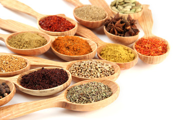 Fototapete Gewürze Assortment of spices in wooden spoons, isolated on white  © Africa Studio
