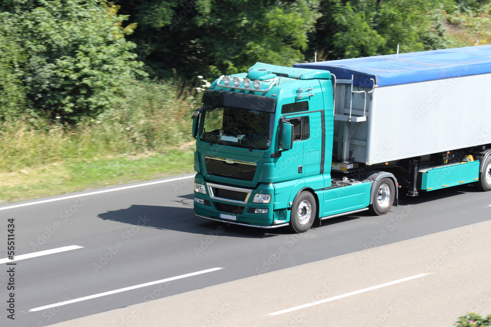 grüner LKW auf der Autobahn