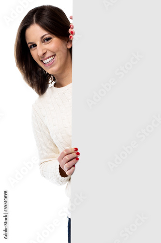 Beautiful young woman holding a blank sign