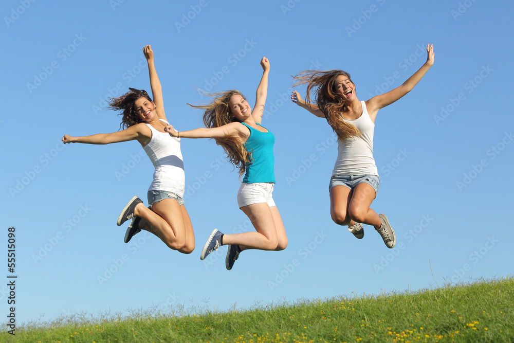 Group of three teenager girls jumping on the grass Group of three teenager girls jumping on the grass